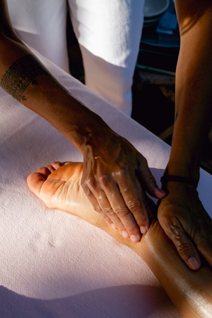 a-person-is-doing-a-foot-massage-on-a-bed-20xfu4op0co
